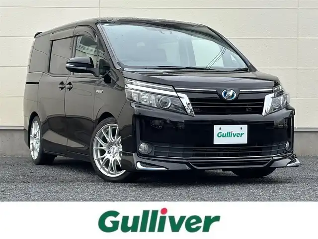 トヨタ ヴォクシー ハイブリッド V 茨城県 2016(平28)年 7.2万km ブラック 10型純正ナビ（AM/FM/TV/Bluetooth/HDMI)/フリップダウンモニター/トヨタセーフティセンスC（衝突回避支援パッケージ）/・プリクラッシュセーフティシステム/・レーンディパーチャーアラート/・オートマチックハイビーム/先行車発進告知機能/前後ドライブレコーダー/シートヒーター/ビルトインETC/クルーズコントロール/LEDヘッドライト/両側パワースライドドア/オートマチックハイビーム/オートライト/純正フロアマット/衝突被害軽減システム/レーンキープアシスト/スペアキー/保証書/取扱説明書