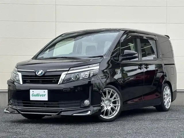 トヨタ ヴォクシー ハイブリッド V 茨城県 2016(平28)年 7.2万km ブラック 10型純正ナビ（AM/FM/TV/Bluetooth/HDMI)/フリップダウンモニター/トヨタセーフティセンスC（衝突回避支援パッケージ）/・プリクラッシュセーフティシステム/・レーンディパーチャーアラート/・オートマチックハイビーム/先行車発進告知機能/前後ドライブレコーダー/シートヒーター/ビルトインETC/クルーズコントロール/LEDヘッドライト/両側パワースライドドア/オートマチックハイビーム/オートライト/純正フロアマット/衝突被害軽減システム/レーンキープアシスト/スペアキー/保証書/取扱説明書