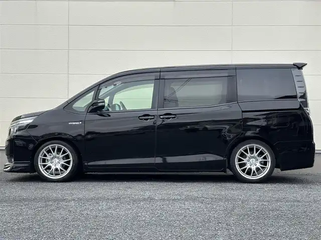 トヨタ ヴォクシー ハイブリッド V 茨城県 2016(平28)年 7.2万km ブラック 10型純正ナビ（AM/FM/TV/Bluetooth/HDMI)/フリップダウンモニター/トヨタセーフティセンスC（衝突回避支援パッケージ）/・プリクラッシュセーフティシステム/・レーンディパーチャーアラート/・オートマチックハイビーム/先行車発進告知機能/前後ドライブレコーダー/シートヒーター/ビルトインETC/クルーズコントロール/LEDヘッドライト/両側パワースライドドア/オートマチックハイビーム/オートライト/純正フロアマット/衝突被害軽減システム/レーンキープアシスト/スペアキー/保証書/取扱説明書