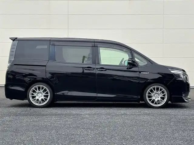 トヨタ ヴォクシー ハイブリッド V 茨城県 2016(平28)年 7.2万km ブラック 10型純正ナビ（AM/FM/TV/Bluetooth/HDMI)/フリップダウンモニター/トヨタセーフティセンスC（衝突回避支援パッケージ）/・プリクラッシュセーフティシステム/・レーンディパーチャーアラート/・オートマチックハイビーム/先行車発進告知機能/前後ドライブレコーダー/シートヒーター/ビルトインETC/クルーズコントロール/LEDヘッドライト/両側パワースライドドア/オートマチックハイビーム/オートライト/純正フロアマット/衝突被害軽減システム/レーンキープアシスト/スペアキー/保証書/取扱説明書