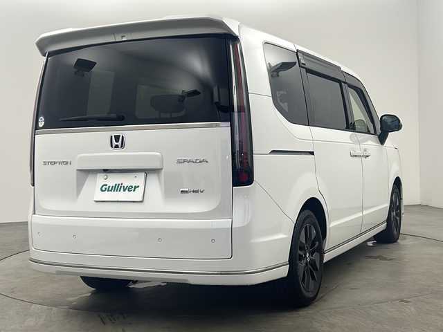 ホンダ ステップワゴン スパーダ eHEV 兵庫県 2022(令4)年 1.2万km プラチナホワイトパール ・純正８インチメモリナビ/CD/DVD/SD/TV/BT/・マルチビューカメラシステム/・ビルトインETC/・ブラインドスポットインフォメーション/・Honda SENSING/・衝突軽減ブレーキ（CMBS）/・誤発進抑制機能/・後方誤発進抑制機能/・近距離衝突軽減ブレーキ/・歩行者事故低減ステアリング/・路外逸脱抑制機能/・渋滞追従機能付アダプティブクルーズコントロール（ACC）/・車線維持支援システム（LKAS）/・トラフィックジャムアシスト（渋滞運転支援機能）/・先行車発進お知らせ機能/・標識認識機能/・オートハイビーム/・アダプティブドライビングビーム/・パワーテールゲート(メモリー機能付)/・ハーフレザーシート/・2列目オットマン/・運転席＆助手席シートヒーター/・トリプルゾーンコントロール・フルオートエアコンディショナー/・コンビシート/・16インチアルミホイール(SPADA専用)/・減速セレクター/・全列USBチャージャー