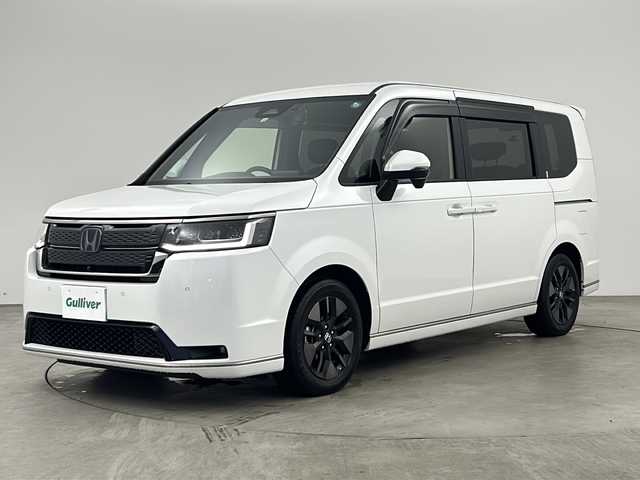 ホンダ ステップワゴン スパーダ eHEV 兵庫県 2022(令4)年 1.2万km プラチナホワイトパール ・純正８インチメモリナビ/CD/DVD/SD/TV/BT/・マルチビューカメラシステム/・ビルトインETC/・ブラインドスポットインフォメーション/・Honda SENSING/・衝突軽減ブレーキ（CMBS）/・誤発進抑制機能/・後方誤発進抑制機能/・近距離衝突軽減ブレーキ/・歩行者事故低減ステアリング/・路外逸脱抑制機能/・渋滞追従機能付アダプティブクルーズコントロール（ACC）/・車線維持支援システム（LKAS）/・トラフィックジャムアシスト（渋滞運転支援機能）/・先行車発進お知らせ機能/・標識認識機能/・オートハイビーム/・アダプティブドライビングビーム/・パワーテールゲート(メモリー機能付)/・ハーフレザーシート/・2列目オットマン/・運転席＆助手席シートヒーター/・トリプルゾーンコントロール・フルオートエアコンディショナー/・コンビシート/・16インチアルミホイール(SPADA専用)/・減速セレクター/・全列USBチャージャー