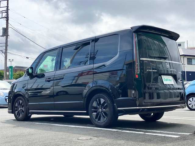ホンダ ステップワゴン スパーダ eHEV 静岡県 2024(令6)年 0.5万km クリスタルブラックパール エンジンスタートボタン/パワーウィンドウ/パワーステアリング/パドルシフト/アイドリングストップ/スマートキー/スペアキー/Wオートエアコン/クルーズコントロール/ETC2.0/USB入力端子/全方位カメラ/純正11.4インチナビ（CD/DVD/BT/フルセグ）/三列シート/オットマン/電動リアゲート/純正ドライブレコーダー前後/ウォークスルー/純正フロアマット/純正アルミホイール/両側パワースライドドア/ハーフレザー/D席N席シートヒーター/ABS/横滑り防止装置/コーナーセンサー前後/レーンキープアシスト/オートライト/オートマチックハイビーム/LEDヘッドライト/W＋サイドエアバック/衝突軽減システム/カーテンエアバック/BSM/ホンダセンシング