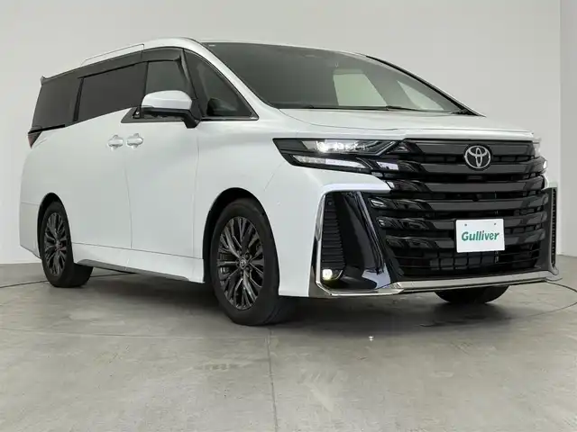 トヨタ ヴェルファイア ハイブリット Z プレミア 愛知県 2024(令6)年 2万km プラチナホワイトパールマイカ 13.2型有機EL後席ディスプレイ/左右独立ムーンルーフ　/純正14型メモリナビ/（FM/AM/BT/フルセグTV）　/全方位バックカメラ　/合皮シート　/前席＋二席目シートベンチレーション/前席＋二席目シートヒーター　/前席＋二席目パワーシート/ステアリングヒーター　/置くだけ充電　/デジタルインナーミラー　/ETC2.0/電動リアゲート/トヨタセーフティセンス/・プリクラッシュセーフティ/・レーンキープアシスト/・ブラインドスポットモニター/・ヘッドアップディスプレイ/・クリアランスソナー/・パーキングサポートブレーキ/・ロードサインアシスト/・レーダークルーズコントロール/・アダクティブハイビームシステム/・両側パワースライドドア/・純正19インチAW/・純正LEDヘッドライト/・純正フロアマット