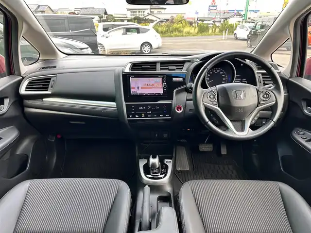 ホンダ フィット ハイブリット L ホンダセンシング 宮城県 2018(平30)年 1.2万km ルージュアメジストM ホンダセンシング/衝突軽減ブレーキ〈CMBS〉/●誤発進抑制機能/●歩行者事故低減ステアリング/●路外逸脱抑制機能/●ACC〈アダプティブ・クルーズ・コントロール〉/●LKAS〈車線維持支援システム〉/●先行車発進お知らせ機能/●標識認識機能/コンフォートビューパッケージ/●親水/ヒーテッドドアミラー/●フロントドア撥水ガラス/●熱線入りフロントウインドウ/純正ナビ（VXM-184VFi）/・CD/DVD/・Bluetooth/・フルセグTV/バックカメラ/ビルトインETC/ドライブレコーダー/ハーフレザーシート/革巻きステアリング/ステアリングスイッチ/LEDヘッドランプ/LEDフォグランプ/オートライト/スマートキー＆プッシュスタート/スペアキー1本/電動格納ミラー/純正フロアマット/ドアバイザー/W/サイド/カーテンエアバッ
