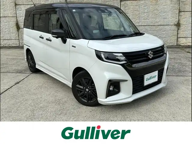 スズキ ソリオ HV SZ 長崎県 2023(令5)年 2.7万km ピュアホワイトパール/ガンメタリック2トーン 純正9インチナビ/（Bluetooth/フルセグ）/全方位カメラ/衝突軽減システム/レーンアシスト/レーダークルーズ/ETC/両側パワースライドドア/ヘッドアップディスプレイ/パドルシフト/前後ドライブレコーダー/バックソナー/純正15インチAW