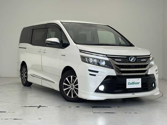 トヨタ ヴォクシー ハイブリッド V 沖縄県 2015(平27)年 9.2万km ホワイトパールクリスタルシャイン 社外ディスプレイオーディオ/Ｂｌｕｅｔｏｏｔｈ/USB/バックカメラ/ＥＴＣ/クルーズコントロール/シートヒーター/両側パワースライドドア/モデリスタエアロ/純正フロアマット/プッシュスタート/スマートキー/オートライト/LEDヘッドライト