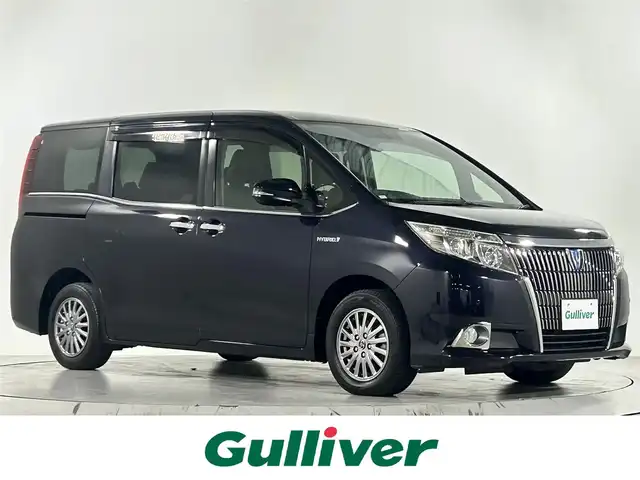 トヨタ エスクァイア ハイブリッド Gi 佐賀県 2015(平27)年 6.5万km スパークリングブラックパールクリスタルシャイン 社外ストラーダ製7インチナビ/フルセグTV/CD/DVD/Bluetooth/アルパイン製10.1インチフリップダウンモニター/トヨタプレミアムサンドシステム/バックカメラ/クルーズコントロール/横滑り防止装置/オートライト/LEDヘッドライト/フォグライト/ビルトインETC/両側パワースライドドア/ワイヤレス充電器/運転席・助手席シートヒーター/合皮シート/後席オートエアコン/純正フロアマット/純正15インチアルミホイール/プッシュスタート