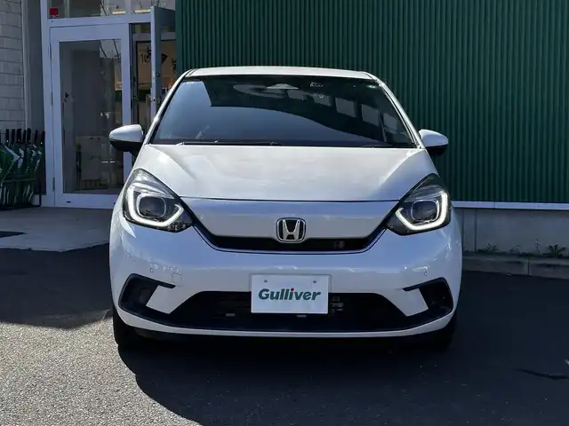 ホンダ フィット e:HEVホーム 宮城県 2020(令2)年 0.6万km プラチナホワイトパール Honda CONNECT for Gathers＋ナビ装着用スペシャルパッケージ/・オーディオリモートコントロールスイッチ/・リアワイドカメラ/・USBジャック/＝＝＝/ホンダセンシング/●衝突軽減ブレーキ〈CMBS〉/●誤発進抑制機能/●後方誤発進抑制機能/●近距離衝突軽減ブレーキ/●歩行者事故低減ステアリング/●路外逸脱抑制機能/●渋滞追従機能付アダプティブ・クルーズ・コントロール〈ACC〉/●車線維持支援システム〈LKAS〉/●先行車発進お知らせ機能/●標識認識機能/●オートハイビーム/コーナーセンサー/純正ナビ（VXM-215Ci）/・CD/SD/・Bluetooth/バックカメラ/ドライブレコーダー/革巻きステアリング/電動パーキングブレーキ/ブレーキホールド/LEDヘッドランプ/オートライト/スマートキー＆プッシュスタート/電動格納ミラー/純正フロアマット/ドアバイザー/W/サイド/カーテンエアバッグ