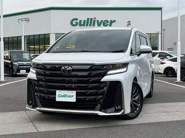トヨタ ヴェルファイア ハイブリット Z プレミア 愛媛県 2023(令5)年 0.9万km プラチナホワイトパールマイカ 登録時走行距離：9038Km/メーカーオプション純正14インチHDナビ/AM/FM/フルセグTV/Bluetooth/ビルトインＥＴＣ2.0/後席モニター/全周囲カメラ/前後ドライブレコーダー/両側パワスラ/電動リアゲート/ワイヤレス充電/パドルシフト/追従クルコン/革シート/デジタルミラー/横滑り防止装置/パーキングアシスト/LEDヘッドライト/オートライト/オートハイビーム/フォグランプ/エンジンスタートボタン/スマートキー/純正アルミホイール/純正フロアマット/シートーヒーター/エアシート/シートメモリ