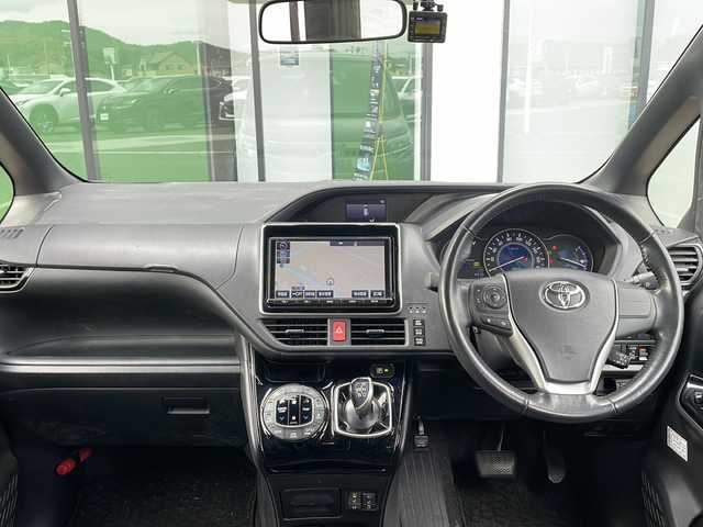 トヨタ ノア ハイブリッド Si 香川県 2018(平30)年 11.6万km ブラッキッシュアゲハガラスフレーク Toyota Safety Sense C/・プリクラッシュセーフティシステム（PCS）/・レーンディパーチャーアラート（LDA）/・オートマチックハイビーム（AHB）/・先行車発進告知機能/純正9型メモリナビ(NSZT-Y66T)/・フルセグTV/・AM/FM/・DVD/CD/・Bluetooth接続/後席モニター（V12T-R66C）/両側パワースライドドア/バックカメラ/パーソナルテーブル/ロールカーテンシェード/純正16インチアルミホイール/純正LEDライト/フロントフォグランプ/横滑り防止機能/レーダークルーズコントロール/前席シートヒーター/前席エアシート/プッシュスタート/スマートキー/ステアリングリモコン/純正フロアマット/ETC/前後ドライブレコーダー/ウィンカーミラー