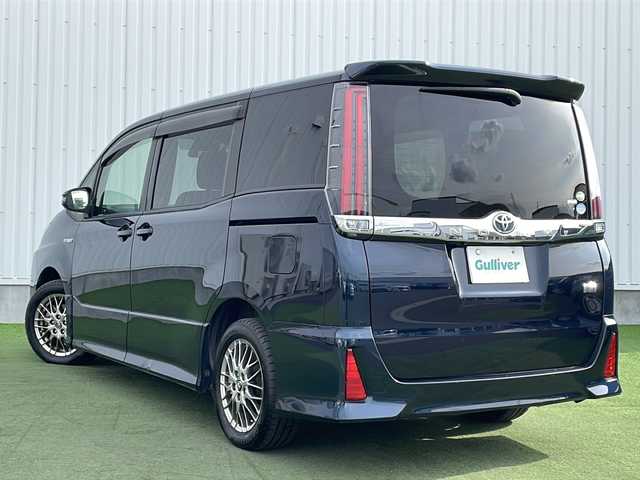 トヨタ ノア ハイブリッド Si 香川県 2018(平30)年 11.6万km ブラッキッシュアゲハガラスフレーク Toyota Safety Sense C/・プリクラッシュセーフティシステム（PCS）/・レーンディパーチャーアラート（LDA）/・オートマチックハイビーム（AHB）/・先行車発進告知機能/純正9型メモリナビ(NSZT-Y66T)/・フルセグTV/・AM/FM/・DVD/CD/・Bluetooth接続/後席モニター（V12T-R66C）/両側パワースライドドア/バックカメラ/パーソナルテーブル/ロールカーテンシェード/純正16インチアルミホイール/純正LEDライト/フロントフォグランプ/横滑り防止機能/レーダークルーズコントロール/前席シートヒーター/前席エアシート/プッシュスタート/スマートキー/ステアリングリモコン/純正フロアマット/ETC/前後ドライブレコーダー/ウィンカーミラー