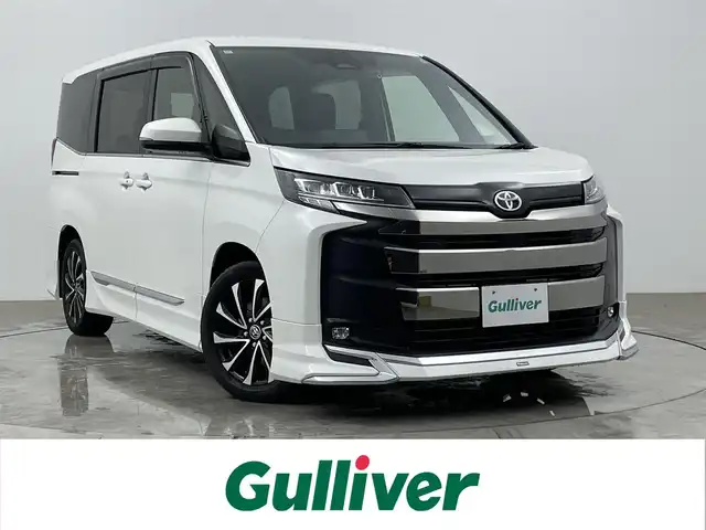 トヨタ ノア S－Z 大分県 2024(令6)年 0.5万km ホワイトパールクリスタルシャイン 純正ディーラーナビ/・Bluetooth・フルセグTV・DISC/・Miracast・AM・FM/バックカメラ/ビルトインETC2.0/ドライブレコーダー/モデリスタエアロ/トヨタセーフティセンス/・プリクラッシュセーフティ/・レーンディパーチャーアラート/・プロアクティブドライビングアシスト/・パーキングサポートブレーキ/・ロードサインアシスト/・クリアランスソナー/レーダークルーズコントロール/後退速度抑制/リアシートリマインダー/前席シートヒーター/両側パワースライドドア/フリップダウンモニター/本革巻きステアリング/ステアリングリモコン/純正フロアマット/純正17インチアルミホイール/テレビキャンセラー/USB端子/HDMI端子/タイプC端子/3眼LEDヘッドライト/フォグランプ/パワーウィンドウ/パワーステアリング/電動格納ミラー