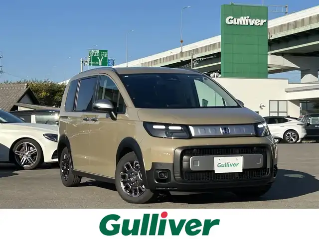 ホンダ フリード ハイブリット e:HEV クロスター 愛知県 2025(令7)年 0.5万km ベージュ 〇ギャザーズディスプレイオーディオ/〇両側パワースライドドア/〇バックカメラ/〇アダプティブクルーズコントロール/〇ホンダセンシング/〇ブラインドスポットインフォメーション/〇オートハイビーム/〇LEDヘッドランプ/〇LEDフロントフォグランプ/〇革巻きシフトノブ/〇革巻きステアリングホイール/〇合皮/撥水ファブリックコンビシート/〇シートヒーター/〇純正15インチアルミホイール/〇スマートキーシステム/〇スペアスマートキー/〇禁煙車