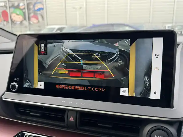 トヨタ プリウス Z 滋賀県 2024(令6)年 2万km ゴールド 禁煙車/純正ディスプレイオーディオ/（Miracast/Bluetooth/USB/フルセグTV）/パノラミックビューモニター/ビルトインETC/デジタルインナーミラー/プリクラッシュセーフティー/レーンディパーチャーアラート/ブラインドスポットモニター/プロアクティブドライビングアシスト/クリアランスソナー/リアクロストラフィックアラート/後方車両接近告知/リヤカメラディテクション/パーキングサポートブレーキ/安心降車アシスト/ロードサインアシスト/革巻きステアリング/レーダークルーズコントロール/ステアリングヒーター/ステアリングリモコン/パワーバックドア/レザーシート/D席シートメモリー/D席パワーシート/前席シートヒーター/前席ベンチレーション/LEDヘッドライト/フォグランプ/オートヘッドライト/オートマチックハイビーム/ヘッドライトレベライザー/電動パーキングブレーキ/オートホールドブレーキ/USB充電/AC100V/置くだけ充電/純正アルミホイール/社外フロアマット