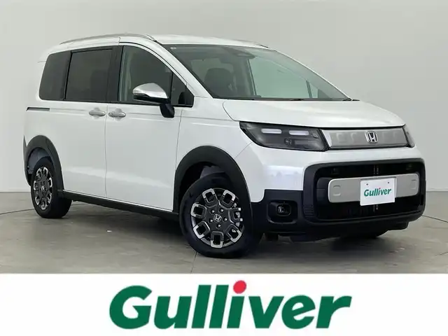 ホンダ フリード ハイブリット e:HEV クロスター 富山県 2025(令7)年 0.1千km プラチナホワイトパール 登録済未使用車/純正9型ナビ（LXM-242ZFNi）/AM/FM/BT/USB/フルセグ/バックカメラ/両側パワースライドドア/ブラインドスポットモニター/衝突被害軽減システム/レーダークルーズコントロール/レーンキープアシスト/コーナーセンサー/横滑り防止装置/オートLEDライト/フォグライト/純正アルミホイール/オートホールド付電子パーキング/革巻きステアリング/ステアリングスイッチ/スマートキー/スペアキー