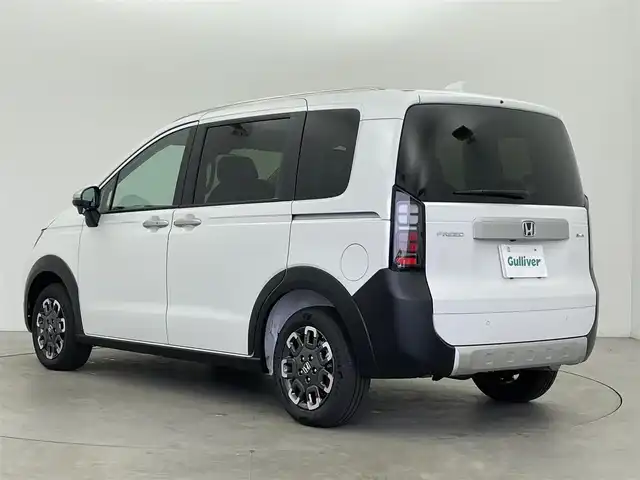 ホンダ フリード ハイブリット e:HEV クロスター 富山県 2025(令7)年 0.1千km プラチナホワイトパール 登録済未使用車/純正9型ナビ（LXM-242ZFNi）/AM/FM/BT/USB/フルセグ/バックカメラ/両側パワースライドドア/ブラインドスポットモニター/衝突被害軽減システム/レーダークルーズコントロール/レーンキープアシスト/コーナーセンサー/横滑り防止装置/オートLEDライト/フォグライト/純正アルミホイール/オートホールド付電子パーキング/革巻きステアリング/ステアリングスイッチ/スマートキー/スペアキー