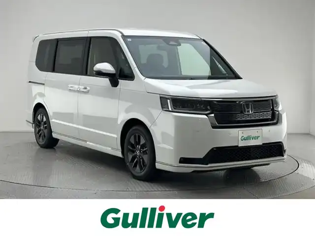 ホンダ ステップワゴン スパーダ eHEV 兵庫県 2025(令7)年 0.1千km プラチナホワイトパール 登録済未使用車/純正１１．４インチメモリナビ　（LXM-247VFLI）/（FM/AM、CD、DVD、BT、フルセグ）/純正１５．６インチ後席モニター/両側パワースライドドア/バックカメラ/レーダークルーズコントロール/パドルシフト/ホンダセンシング/ホンダコネクト/プッシュスタート/電動格納ミラー/ウィンカーミラー/ハーフレザーシート/シートヒーター（D/N席）/パワーバックドア/BSM/オットマン/LEDヘッドライト/LEDフォグランプ/オートライト/純正１６インチAW/本革巻ステアリングホイール/スマートキー×２