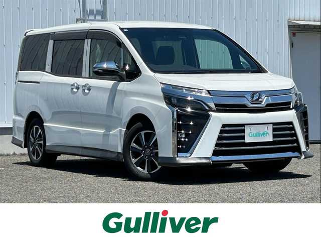 トヨタ ヴォクシー ZS 熊本県 2018(平30)年 6.9万km ホワイトパールクリスタルシャイン 社外SDナビ（ALPINE）/・AM/FM/CD/DVD/SD/AUX/USB/BT/・フルセグTV/バックカメラ/トヨタセーフティセンス/・プリクラッシュセーフティシステム/・レーンディパーチャーアラート/・先行車発進お知らせ機能/・オートマチックハイビーム/・トラクションコントロールシステム/革巻きステアリング/・ステアリングリモコン/ビルトインETC/ドライブレコーダー/オートライト/・LEDライト/・フォグライト/電動格納ミラー/・ウィンカーミラー/・ドアミラーバイザー/ドアバイザー/純正アルミホイール/社外フロアマット/スマートキー
