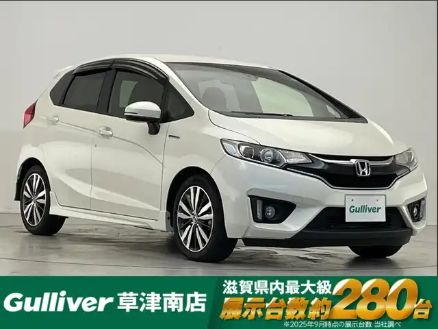 ホンダ フィット ハイブリット Sパッケージ 滋賀県 2016(平28)年 5.4万km プレミアムホワイトパールⅡ 純正ナビ/Bluetooth/CD/DVD/フルセグ/バックカメラ/クルーズコントロール/衝突軽減装置/LEDヘッドライト/フォグランプ/オートライト/ETC/パドルシフト/ステアリングスイッチ/革巻きハンドル/純正フロアマット/純正16インチアルミホイール/リアスポイラー/ドアバイザー/プッシュスタート/スマートキー