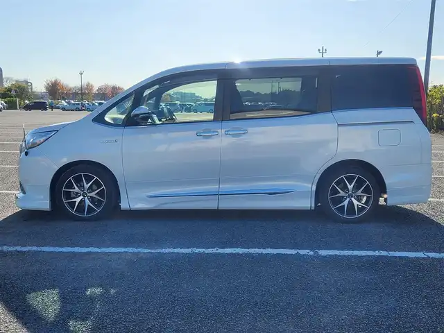 トヨタ エスクァイア ハイブリッド Gi 群馬県 2015(平27)年 7.1万km ホワイトパールクリスタルシャイン モデリスタエアロ(F/S/R)/純正9型ナビ/フルセグTV/純正11型後席ディスプレイ/両側パワースライドドア/バックモニター/ビルトインETC/ドライブレコーダー/クルーズコントロール/クリアランスソナー/LEDヘッドランプ/オートライト/デュアルオートエアコン/木目調/革巻きコンビステアリング/ステアリングスイッチ/合皮シート/モデリスタ17インチアルミホイール/スマートキー/プッシュエンジンスタート/禁煙車