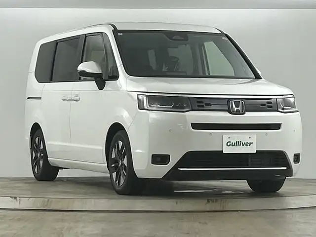 ホンダ ステップワゴン eHEV エアー EX 愛知県 2025(令7)年 0.1千km カジノホワイトパール 登録済未使用車/ターボ/純正11.4インチナビ/（CD/DVD/Bluetooth/フルセグTV/USB/SD)/バックカメラ/純正15.6インチフリップダウンモニター/ホンダセンシング/・衝突軽減ブレーキ/・レーンキープアシスト/・オートハイビーム/・ブラインドスポットモニター/・パーキングセンサー/・アダプティブクルーズコントロール/・誤発進抑制機能/シートヒーター/オットマン/両側パワースライドドア/パワーバックドア/パドルシフト/純正16インチアルミホイール/スマートキー/スペアキー1本/プッシュスタート/LEDヘッドライト/フロントフォグランプ/オートライト/横滑り防止装置/電子パーキングブレーキ/オートホールド/電動格納ミラー