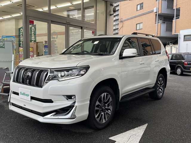 トヨタ ランドクルーザー プラド TX Lパッケージ 大阪府 2023(令5)年 1.4万km ホワイトパールクリスタルシャイン 純正ディスプレイオーディオ/純正メモリーナビ/Bluetoothオーディーオ/Miracast/全周囲モニター/バックカメラ/衝突軽減ブレーキ/車線逸脱警報/サイドブラインドモニター/RSA/先行車発進告知/レーダークルーズコントロール/ビルトインETC2.0/サンルーフ/レザーシート/エアーシート/シートヒーター/スマートキー/LEDライト/フロントモデリスタエアロ/ルーフレール