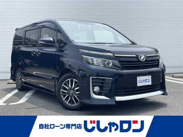 トヨタ ヴォクシー ZS 熊本県 2014(平26)年 13.5万km ブラッキッシュアゲハガラスフレーク (株)IDOMが運営する【じしゃロン熊本店】の自社ローン専用車両になりますこちらは現金またはオートローンご利用時の価格です。自社ローンご希望の方は別途その旨お申付け下さい/Panasonic製SDナビ【CNーRE03WD】/　（フルセグTV・Bluetooth・DVD・CD・AM/FM）/ビルトインETC/前後ドライブレコーダー/ステアリングスイッチ/両側パワースライドドア/横滑り防止装置/アイドリングストップ/ドアバイザー/電動格納ウィンカーミラー/ISOFIX/純正フロアマット/純正LEDヘッドライト/純正16インチアルミホイール