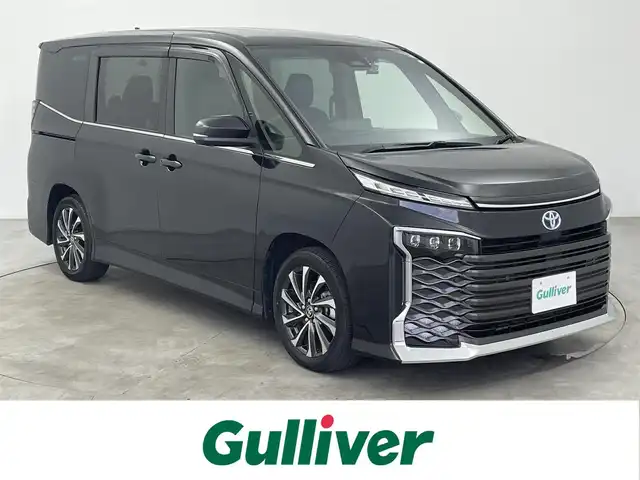 トヨタ ヴォクシー ハイブリッド S－Z 大分県 2023(令5)年 2.5万km グリッターブラックガラスフレーク セーフティセンス/・プリクラッシュセーフティ/・レーンディパーチャーアラート/・オートマチックハイビーム/・レーダークルーズ/・ロードサインアシスト/・発進遅れ告知機能/純正10.5インチディスプレイナビ/・フルセグTV/・Bluetooth接続/・Miracast/純正14インチフリップダウンモニター/快適利便パッケージ/AC100V 1500w/HDMI/タイプC/LEDヘッドライト/両側パワースライドドア/電動リアゲート/3列シート/バックカメラ/コーナーセンサー/ハーフレザーシート/ステアリングヒーター/ドライブレコーダー/ETC/スペアキー