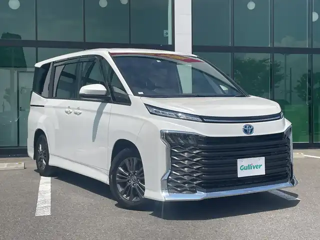 トヨタ ヴォクシー ハイブリッド S－G 大阪府 2022(令4)年 2万km ホワイトパールクリスタルシャイン 純正10.5インチナビ/（BT/CD/DVD/HDMI)/フルセグTV/バックカメラ/衝突軽減ブレーキ/レーンキープアシスト/横滑り防止/レーダークルーズコントロール/オートライト/前後コーナーセンサー/フリップダウンモニター/ビルトインETC2.0/前後ドラレコ/デジタルインナーミラー/前席シートヒーター/両側パワスラ/LEDヘッドライト/純正16インチアルミ/純正フロアマット