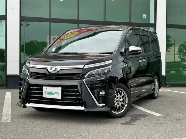 トヨタ ヴォクシー ハイブリッド ZS 煌Ⅱ 和歌山県 2019(令1)年 6.2万km ブラック 純正ナビ（NSZT-Y68T）/フルセグTV/（BT/CD/DVD）/バックカメラ/横滑り防止/衝突被害軽減ブレーキ/レーンキープアシスト/クルーズコントロール/オートライト/前後コーナーセンサー/フリップダウンモニター/前方ドラレコ/ビルトインETC/両側パワスラ/前席シートヒーター/LEDヘッドライト/フォグランプ/ステアリングリモコン/ステアリングヒーター/純正16インチアルミ/純正フロアマット