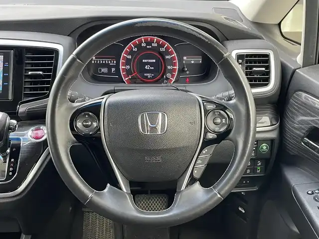 ホンダ オデッセイ アブソルート 埼玉県 2015(平27)年 10.4万km プレミアムヴィーナスブラックP (株)IDOMが運営する【じしゃロン鳩ヶ谷店】の自社ローン専用車両になりますこちらは現金またはオートローンご利用時の価格です。自社ローンご希望の方は別途その旨お申付け下さい/ホンダセンシング/  衝突軽減ブレーキ〈CMBS〉/  誤発進抑制機能/  LKAS〈車線維持支援システム〉/  路外逸脱抑制機能/  ACC〈アダプティブ・クルーズ・コントロール〉/純正ナビ　/　AM/FM/CD/DVD/BT/フルセグTV/バックカメラ　/フリップダウンモニター　/両側パワースライドドア　/パドルシフト　/ステアリングスイッチ　/デュアルエアコン　/キャプテンシート　/オットマン（２列目）/ビルトインＥＴＣ/フォグランプ/プッシュスタートボタン/スマートキー×2/ドアバイザー/電動格納式ウィンカーミラー/保証書