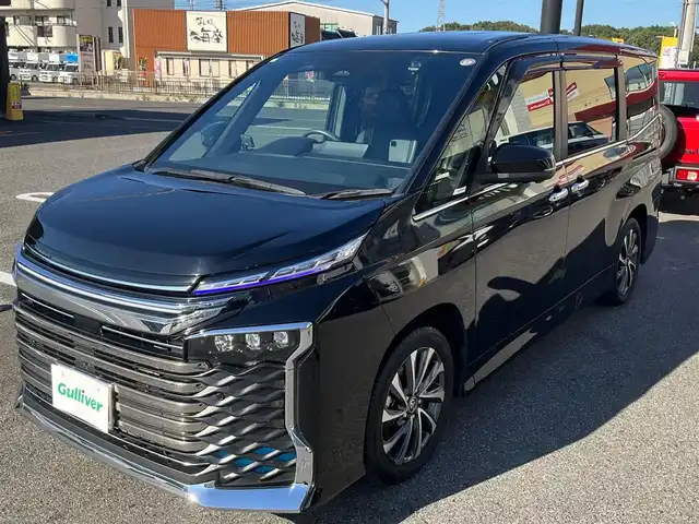 トヨタ ヴォクシー ハイブリッド S－Z 滋賀県 2023(令5)年 2.6万km アティチュードブラックマイカ ワンオーナー /車検令和8年7月まで/3列シート7人乗り/両側パワースライドドア/純正17インチアルミホイール/LED3プロジェクター3眼ヘッドライト/・LED薄暮灯/ハーフレザーシート/MOPディスプレイオーディオプラス/・10.5インチディスプレイメモリーナビ/・フルセグTV/・CD/DVD/・Bluetooth/・ETC2.0/MOPトヨタチームメイト/・パノラミックビューモニター/・アドバンスドパーク/・パーキングサポートブレーキ/・エレクトロシフトマチック/MOP快適利便パッケージHIGH/・パワーバックドア/・ナノイーX/・ステアリングヒーター/・2列目シートヒーター/・オットマン（2列目）/取扱説明書/保証書/