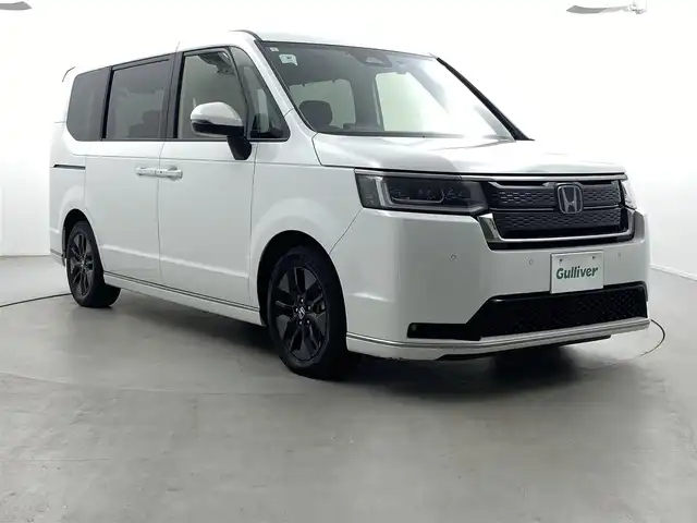 ホンダ ステップワゴン スパーダ eHEV 福井県 2024(令6)年 1.3万km プラチナホワイトパール 純正11インチナビ（LXM-247VFLi）/-フルセグTV/CD/DVD/Bluetooth/USB/AppleCarPlay/AndroidAuto/純正フロアマット/前後ドライブレコーダー/バックカメラ/ホンダセンシング/衝突軽減ブレーキ/BSM/パワーテールゲート/前後コーナーセンサー/両側パワースライドドア/レーダークルーズコントロール/レーンキープアシスト/ハーフレザーシート/前席シートヒーター/オットマン/パドルシフト/トリプルゾーンAC/16インチAW/電子ブレーキ/ブレーキホールド/オートライト/オートハイビーム/LEDヘッドライト/背面テーブル
