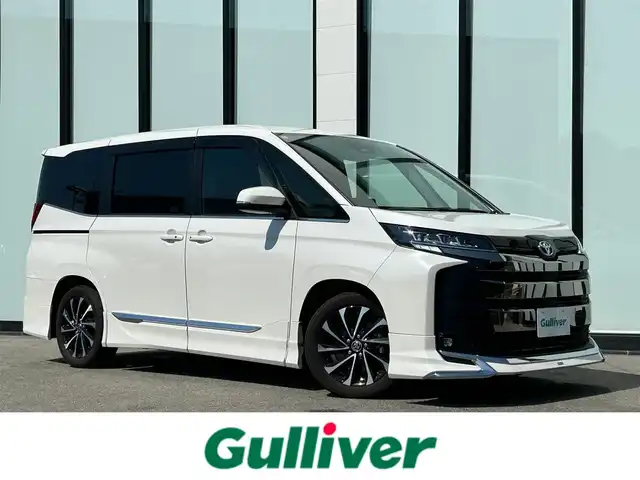 トヨタ ノア S－Z 大阪府 2022(令4)年 1.9万km ホワイトパールクリスタルシャイン モデリスタエアロ/快適利便パッケージ/  ・両側パワースライドドア/  ・電動リアゲート/  ・全席シートヒーター/  ・ナノイーX/  ・オットマン/純正１０．５インチナビ　/   フルセグTV/Bluetooth/USB/CD/DVDデッキ　/バックモニター　/１４インチ後席モニター　/衝突軽減ブレーキ/クリアランスソナー　/レーダークルーズコントロール/レーンキープアシスト　　/前方ドライブレコーダー　/純正17インチアルミホイール/純正フロアマット/プッシュスタート/スマートキー　/ビルトインＥＴＣ2.0　/ＬＥＤ