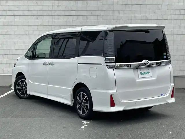 トヨタ ヴォクシー ZS 煌Ⅱ 愛知県 2019(令1)年 2万km ホワイトパールクリスタルシャイン ・純正SDメモリーナビ/・バックカメラ/・フルセグTV/・CD/DVD再生/・ETC（新セキュリティ対応）/・Bluetooth/USB/IWCH接続/・3列シート/・両側パワースライドドア/・社外製フロアマット/・ウォークスルー（1列目）/・純正16インチアルミホイール/・LEDヘッドライト/・オートマチックハイビーム/・コーナーセンサー（後方）/・横滑り防止装置/・衝突軽減ブレーキ/・レーンキープアシスト/・ドライブレコーダー（前）/・充電用USBポート（2個）/・クルーズコントロール/・MTモード付きAT/・全席オートエアコン/・カロッツェリアスピーカー/・モデリスタ シグネチャーイルミブレード