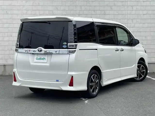 トヨタ ヴォクシー ZS 煌Ⅱ 愛知県 2019(令1)年 2万km ホワイトパールクリスタルシャイン ・純正SDメモリーナビ/・バックカメラ/・フルセグTV/・CD/DVD再生/・ETC（新セキュリティ対応）/・Bluetooth/USB/IWCH接続/・3列シート/・両側パワースライドドア/・社外製フロアマット/・ウォークスルー（1列目）/・純正16インチアルミホイール/・LEDヘッドライト/・オートマチックハイビーム/・コーナーセンサー（後方）/・横滑り防止装置/・衝突軽減ブレーキ/・レーンキープアシスト/・ドライブレコーダー（前）/・充電用USBポート（2個）/・クルーズコントロール/・MTモード付きAT/・全席オートエアコン/・カロッツェリアスピーカー/・モデリスタ シグネチャーイルミブレード