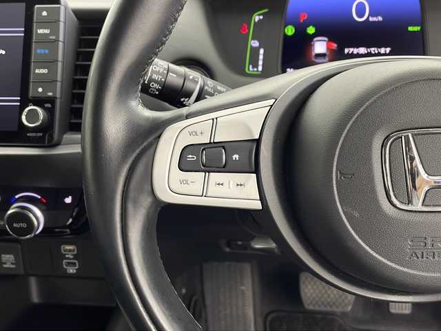 ホンダ フィット e:HEVリュクス 鹿児島県 2020(令2)年 1.8万km シャイニンググレーM ホンダセンシング　/●衝突軽減ブレーキ〈CMBS〉/●誤発進抑制機能/●後方誤発進抑制機能/●近距離衝突軽減ブレーキ/●歩行者事故低減ステアリング/●路外逸脱抑制機能/●渋滞追従機能付アダプティブ・クルーズ・コントロール〈ACC〉/●車線維持支援システム〈LKAS〉/●先行車発進お知らせ機能●標識認識機能/●オートハイビーム/純正９型ナビ　/前後ドライブレコーダー　/電子パーキング　/オートホールド　/ハンドルヒーター　/フォグライト　/LEDヘッドライト/ドアバイザー　/ウインカーミラー　/シートヒーター/ワイヤレス充電器/純正アルミホイール