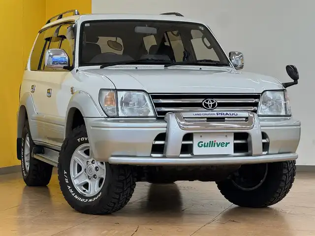 トヨタ ランドクルーザー プラド TX ワイド パッケージⅢ 群馬県 1998(平10)年 7.4万km ホワイト/シルバーM 8ナンバー登録/.ベッド【180×50】/・キャンピングタンク/・コンロ/社外SDナビ/　　iPod/USB/SD/CD/DVD/ワンセグ/バックカメラ/サンルーフ/ルーフレール/オートエアコン/シートカバー付/純正16インチアルミ/背面タイヤ/キャンピング/ETC