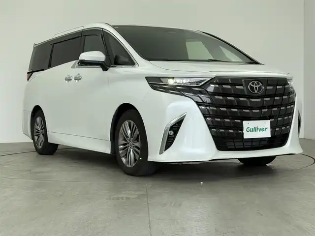トヨタ アルファードハイブリット Z 愛知県 2024(令6)年 2.1万km プラチナホワイトパールマイカ 13.2型有機EL後席ディスプレイ　/純正14型メモリナビ/（FM/AM/BT/フルセグTV）　/全方位バックカメラ　/合皮シート　/前席＋二席目シートベンチレーション/前席＋二席目シートヒーター　/前席＋二席目パワーシート/ステアリングヒーター　/置くだけ充電　/デジタルインナーミラー　/ETC2.0/電動リアゲート/トヨタセーフティセンス/・プリクラッシュセーフティ/・レーンキープアシスト/・ブラインドスポットモニター/・ヘッドアップディスプレイ/・クリアランスソナー/・パーキングサポートブレーキ/・ロードサインアシスト/・レーダークルーズコントロール/・アダクティブハイビームシステム/・両側パワースライドドア/・純正19インチAW/・純正LEDヘッドライト/・純正フロアマット