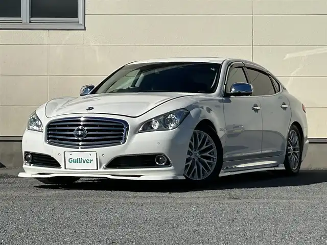 日産 シーマ ハイブリッド VIP G 茨城県 2017(平29)年 7.8万km クリスタルホワイトパール 純正ナビ/（AM/FM/CD/DVD/AUX/Bluetooth）/フルセグ/サンルーフ/BOSEサウンド/後席プライベートシアターシステム/純正アカンサスエンブレム/純正リアスポイラー/エアロパーツ（フロント・サイド）/純正リモコンエンジンスターター/全方位カメラ/電動リアシェード/全席本革パワーシート/シートヒーター（全席）/エアシート（前席）/オットマン（N席）/前方ドライブレコーダー/ビルトインETC/追従型クルーズコントロール/ブラインドスポットモニター/社外サス/純正アルミホイール/純正フロアマット