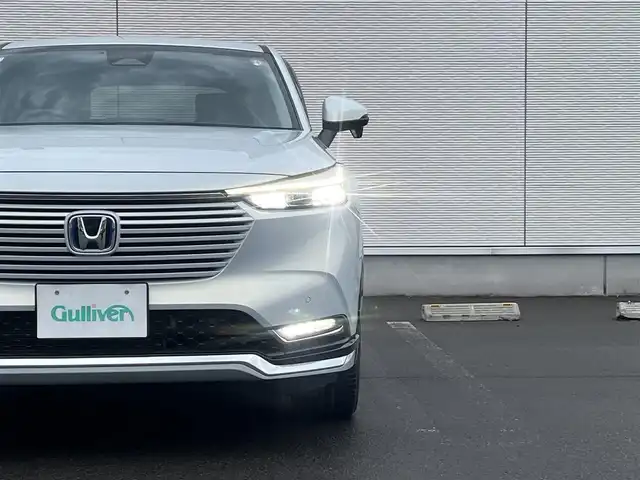 ホンダ ヴェゼル ハイブリッド e:HEV Z 秋田県 2023(令5)年 3.6万km プレミアムサンライトホワイトパール ４WD/衝突軽減システム/LEDヘッドライト/純正メモリナビ（DVD/CD/BT/AM/FM/USB）/フルセグ（走行中視聴可能）/バックカメラ/ホンダ純正１８インチアルミ（夏タイヤ装着）/スマートキー/アイドリングストップ/プッシュスタート/コーナーセンサー/レーンキープアシスト/クルーズコントロール追従走行あり/オートマチックハイビーム/ダウンヒルアシストコントロール/ステアリングスイッチ/ステアリングヒーター/パドルシフト/前席シートヒーター/ビルトインETC/電動リアゲート/電動パーキングブレーキ/オートブレーキホールド機能/純正フロアマット/社外ドアバイザー/オートライト/オートエアコン/パワーステアリング/パワーウィンドウ/横滑り防止/盗難防止装置/寒冷地仕様/電動格納ウィンカーミラー/保証書/取扱説明書/記録簿