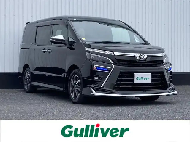 トヨタ ヴォクシー ZS 煌Ⅲ 千葉県 2021(令3)年 3.4万km イナズマスパーキングブラックガラスフレーク 純正10インチナビ/(フルセグTV/BT/CD/DVD/FM/AM)/バックカメラ/モデリスタエアロ/衝突被害軽減システム/車線逸脱警報/クルーズコントロール/純正フリップダウンモニター/ハーフレザーシート/両側パワースライドドア/横滑り防止装置/ETC/アイドリングストップ/LEDヘッドライト/フォグランプ/オートライト/ウィンカーミラー/電動格納ミラー/純正16インチAW/シートリフター/プッシュスタート/スマートキー/スペアキー/フロアマット/ドアバイザー/取扱説明書/保証書