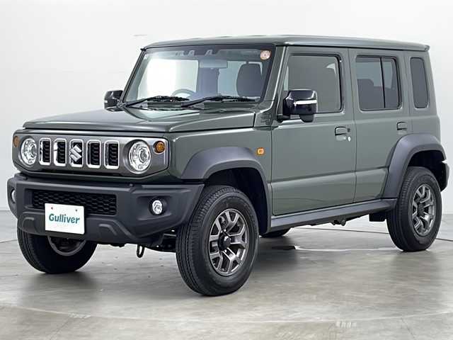 スズキ ジムニー ノマド FC 道央・札幌 2025(令7)年 0.2万km ＤグリーンＭ ・4WD/・社外ディスプレイオーディオ　BT/・バックカメラ/・スマートキー/・プッシュスタート/・スズキセーフティーサポート/・衝突被害軽減ブレーキ/・先行車発進お知らせ/・標識認識機能/・車線逸脱警報/・ふらつき警報/・前後誤発進抑制機能/・アートマチックハイビーム/・ダウンヒルアシストコントロール/・アイドリングストップ/・シートヒーターDN席/・ミラーヒーター/・ビルトインETC/・オートライト/・LEDヘッドライト/・フォグ/・ヘットライトウオッシャー