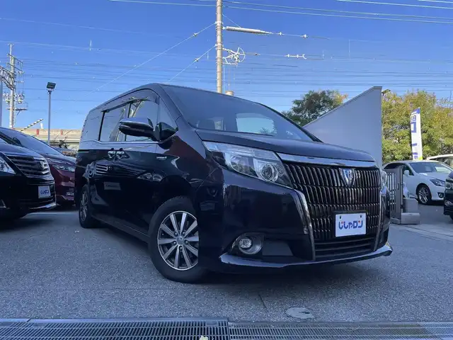 トヨタ エスクァイア ハイブリッド Gi ブラックテーラード 兵庫県 2016(平28)年 12.6万km スパークリングブラックパールクリスタルシャイン (株)IDOMが運営する【じしゃロン西宮店】の自社ローン対象車両になります。こちらは現金ご利用時の価格です。/自社ローンご希望の方は別途その旨お申付け下さい。/＊ETC/＊バックカメラ/＊パワステ/＊パワーウィンドウ/＊クルーズコントロールあり/＊純正10インチナビ/＊ドラレコあり/＊レザーシート/＊シートヒーター/＊エアシート/＊両側パワステ/＊横滑り防止装置/＊レーンキープアシスト/＊オートライト/＊衝突被害軽減システム