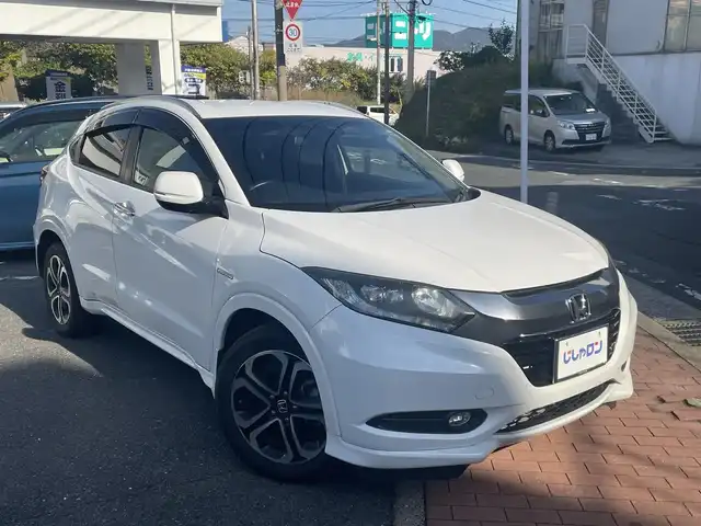 ホンダ ヴェゼル ハイブリッド Z 福岡県 2015(平27)年 10.3万km ホワイトオーキッドパール (株)IDOMが運営する【じしゃロン八幡西店】の自社ローン専用車両になります。こちらは現金またはオートローンご利用時の価格です。自社ローンご希望の方は別途その旨お申付け下さい/スマートキー/純正メモリナビ/Bluetooth/フルセグ/バックカメラ/クルーズコントロール/パドルシフト/シートヒーター/ETC