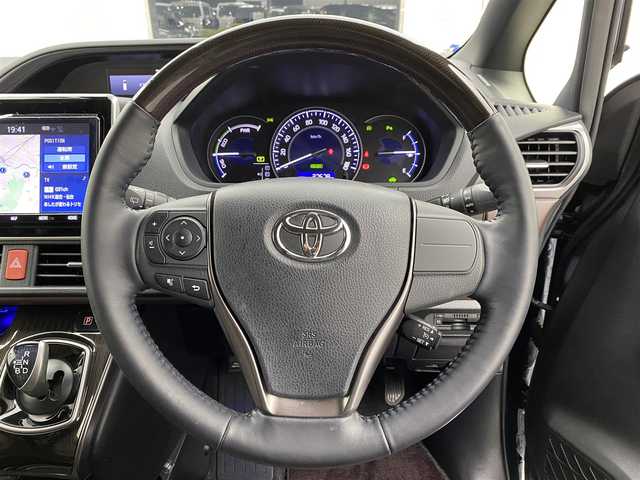 トヨタ エスクァイア ハイブリッド Gi プレミアムパッケージ 宮城県 2019(平31)年 2.8万km ブラッキッシュアゲハガラスフレーク 純正9インチナビ/（NSZT-Y68T)/純正フリップダウンモニター/純正OPエアロ/安全装備/・衝突被害軽減システム/・横滑り防止装置/・レーンキープアシスト/アイドリングストップ/クルーズコントロール/ETC/スマートキー/バックカメラ/フルセグテレビ/USB入力端子/ハーフレザー/シートヒーター/両側パワースライド/コーナーセンサー/ドライブレコーダー