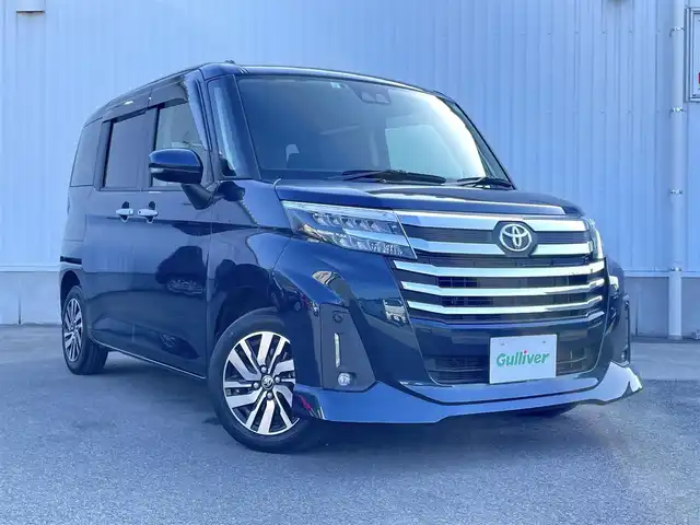 トヨタ ルーミー カスタムG 愛媛県 2023(令5)年 1.8万km レーザーブルークリスタルシャイン スマートアシスト/衝突回避支援ブレーキ/車線逸脱警報/ブレーキ制御付御発進抑制機能/アダプティブクルーズコントロール/先行車発進お知らせ機能/ふらつき警報/路外逸脱警報/標識認識機能/社外7インチナビ【AVN-R10W】/　CD/DVD/Bluetooth/フルセグTV/ビルトインETC/両側パワースライドドア/オートライト/LEDヘッドライト/フロントフォグ/革巻きステアリング/電子パーキングブレーキ/フロアマット/ドアバイザー