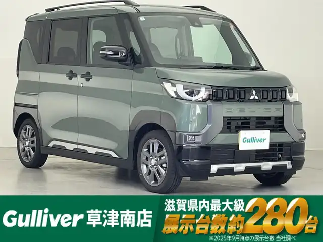 三菱 デリカミニ T プレミアム 滋賀県 2025(令7)年 0.1千km 緑Ⅱ 純正9インチディスプレイオーディオ/【Bluetooth/Apple CarPlay/Android Auto】/両側パワースライドドア/全方位カメラ/ハーフレザーシート/MI-PILOT/クリアランスソナー/LEDヘッドライト/オートマチックハイビーム/レーンキープアシスト/衝突軽減ブレーキ/ヒルディセントコントロール/D/Nシートヒーター/ステアリングヒーター/デジタルインナーミラー/ルーフレール/電動パーキングブレーキ/オートブレーキホールド/プッシュスタート/スマートキー/ステアリングリモコン