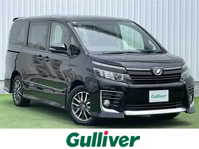 トヨタ ヴォクシー ZS 香川県 2014(平26)年 6.8万km ブラック 登録時走行距離：67683km/ディーラー純正ナビ/バックカメラ/純正11型フリップダウンモニター/両側パワースライドドア/LEDヘッドライト/オートライト/フォグランプ/ビルトインETC/ロールサンシェード/プッシュスタート/スマートキー/スペアキー